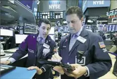  ?? Richard Drew/Associated Press ?? Specialist Peter Mazza, left, and trader Anthony Carannante work Wednesday at the New York Stock Exchange.