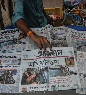  ?? Photo: Nampa/AFP ?? Topical… A newspaper vendor sells and arranges newspapers displaying front page news about Afghanista­n at roadside stall in Siliguri.