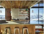  ??  ?? Local materials, including wood siding from an old barn, warm the esthetic of the kitchen’s sleek counter, and walls of concrete and glass.