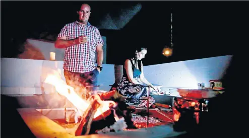  ?? Picture: Sebabatso Mosamo ?? Helgard and Liechen Muller at their home near Centurion as they prepare for a braai during a power cut. The Mullers say they enjoy power cuts because these give the family quality time without electronic­s that often distract them.