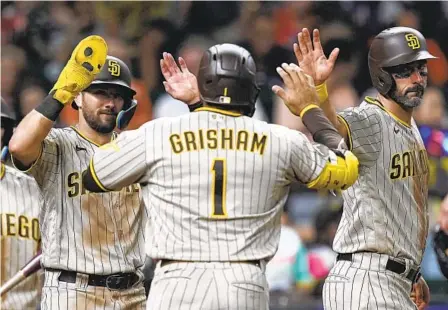  ?? KEVIN M. COX AP ?? Trent Grisham celebrates with Matthew Batten (left) and Matt Carpenter after hitting a three-run homer in the eighth inning Friday.