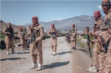  ?? JIM HUYLEBROEK/THE NEW YORK TIMES ?? Members of the Taliban’s elite “Red Unit” wear white high-top sneakers with green-and-yellow trim in Laghman, Afghanista­n. Called Cheetahs, the shoes have been favored by insurgents for decades.