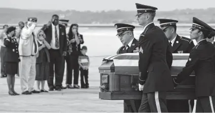  ?? Bob Owen / San Antonio Express-News ?? Members of the U.S. Army Honor Guard carry the casket of Army Lt. Clovis Ray as family members watch nearby.