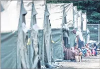  ?? CP PHOTO ?? Asylum seekers sit in front of their tent in a temporary camp Tuesday near Saint-bernard-de-lacolle, Que. The camp was set up to cope with the crush of asylum seekers crossing into Canada from the United States.