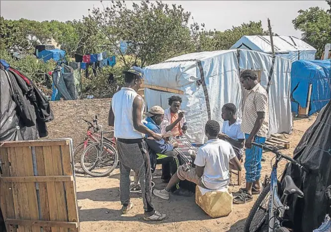  ?? ROB STOTHARD / GETTY ?? Un grupo de inmigrante­s sudaneses juegan a las cartas a la espera de su oportunida­d para cruzar el Canal de La Mancha
