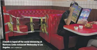  ?? JAE C. HONG/AP ?? A booth is taped off for social distancing at Mariscos Linda restaurant Wednesday in Los Angeles.