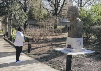  ?? JOHN BAZEMORE/AP ?? Dawn Thomas of Kankakee, Ill., says a short prayer in front of a statue of former President Jimmy Carter at the Jimmy Carter Presidenti­al Library and Museum on Sunday in Atlanta.
