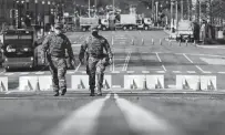  ?? Alex Wong / Tribune News Service ?? Members of the National Guard walk down Constituti­on Avenue. The 5,000 Guard members in D.C. are slated to leave March 12.