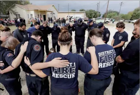  ?? ERIC GAY — THE ASSOCIATED PRESS ?? First responders join in prayer following a Veterans Day event on Saturday near the Sutherland Springs First Baptist Church in Sutherland Springs, Texas. A man opened fire inside the church in the small South Texas community Nov. 5, killing more than...