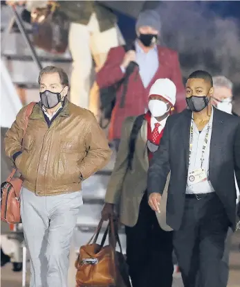  ?? CURTIS COMPTON/AP ?? Alabama coach Nick Saban, left, and the team get off the plane at an airport in Indianapol­is on Friday.