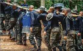  ?? LAUREN DECICCA / GETTY IMAGES ?? Thai military members bring water pumps to the cave in Thailand where 12 boys and their soccer coach have been trapped for almost two weeks.