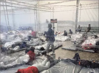  ?? Associated Press ?? This Saturday photo, provided by the Office of Rep. Henry Cuellar, D-Texas, shows detainees in a Customs and Border Protection temporary overflow facility in Donna, Texas.