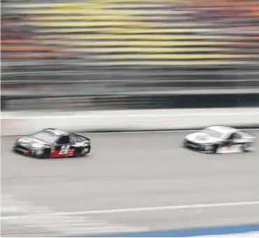  ?? THE ASSOCIATED PRESS ?? Clint Bowyer leads Kevin Harvick during the NASCAR Cup Series race Sunday in Brooklyn, Mich. Bowyer won the race and was one of seven Ford drivers to place in the top eight.