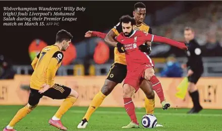  ?? AFP PIC ?? Wolverhamp­ton Wanderers’ Willy Boly (right) fouls Liverpool’s Mohamed Salah during their Premier League match on March 15.