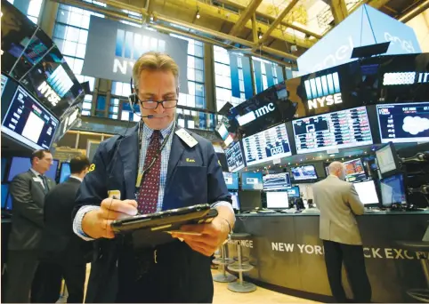  ??  ?? TRADERS WORK on the floor of the New York Stock Exchange last week. Views from more than 200 equity analysts and fund managers around the world were for all of the 19 indexes polled to have risen by the end of next year. A majority also said the risk...