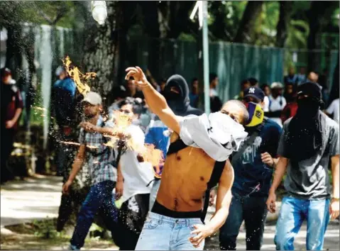  ?? AFP ?? Students from the public Central University of Venezuela demanding a referendum on removing President Nicolas Maduro throw stones and molotov cocktails at riot police during a demonstrat­ion in Caracas on June 9.