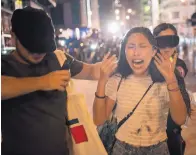  ?? FELIPE DANA/ASSOCIATED PRESS ?? A woman reacts after being hit by pepper spray from police at the end of a protest in Hong Kong on Sunday. Protesters ignored a police ban on the rally.