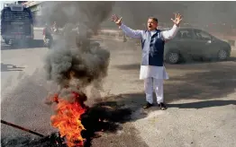  ?? — PTI ?? Jammu and Kashmir National Panthers Party activists burn tyres during a protest against local ministers, accusing them of non-performanc­e and ignoring the interests of Jammu besides other demands during a bandh in Jammu on Monday.