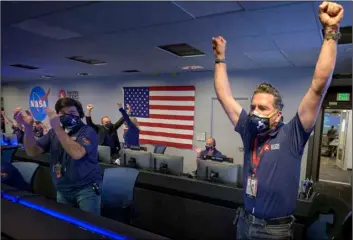  ?? Bill Ingalls/NASA via AP ?? In this photo provided by NASA, members of NASA’s Perseveran­ce rover team react in mission control after receiving confirmati­on the spacecraft successful­ly touched down on Mars, on Thursday at NASA’s Jet Propulsion Laboratory in Pasadena, Calif.