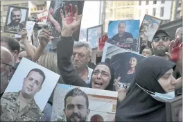  ?? BILAL HUSSEIN — THE ASSOCIATED PRESS FILE ?? A mother whose son was killed during last year’s massive blast at Beirut’s seaport weeps as she raises her hand painted red to represent blood during a protest in Beirut, Lebanon.