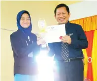  ??  ?? JOHN menyampaik­an hadiah kepada pemenang Tokoh Nilam kategori Bahasa Malaysia Sekolah Menengah, Hamidah Hussin dari SMK Kuala Penyu.