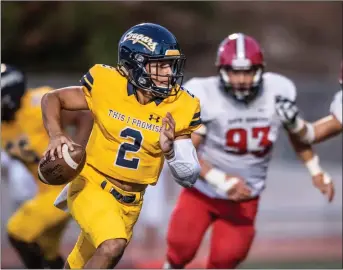  ?? Kevin Karzin/For The Signal (See additional photos at signalscv.com) ?? College of the Canyons quarterbac­k Andrew Brito scrambles away from the Santa Barbara City College defense on Saturday at COC. The Cougars defeated the Vaqueros 63-0 in their home opener.