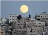  ?? PHOTO: REUTERS ?? The moon rises over Amman, Jordan.
