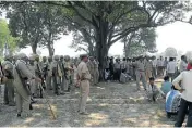  ??  ?? SCENE OF THE CRIME: Villagers and policemen gather at the mango tree in Katra village in Uttar Pradesh where the two teenage cousins were found hanging after being gang-raped