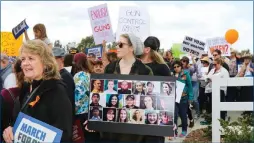  ?? Geogia Rios/The Signal ?? (Left) Students, families, faculty, and political leaders came together at March for Our Lives protest for safer gun laws and safer schools on Saturday. (Above) A woman holds a poster with photos of the victims of the Parkland, Florida shooting during...