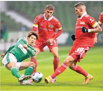  ?? FOTO: CARMEN JASPERSEN/DPA ?? Werder Bremens Yuya Osako (l.) bekommt im Dreikampf mit den Berlinern Robert Andrich (r.) und Grischa Prömel das intensive Spiel der Unioner zu spüren.