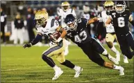  ?? Stephen Dunn / Associated Press ?? Navy wide receiver Garrett Winn (26) is chased down by UConn linebacker Jackson Mitchell (43) during the second half during a game in 2019.