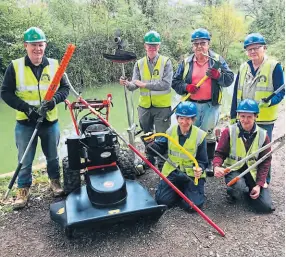  ?? PHOTO: JUSTIN GUY ?? Dave Maloney, second from left, and fellow volunteers in front of the restored canal at Pewsham, with some of the new equipment funded by Chippenham Borough Lands Charity.