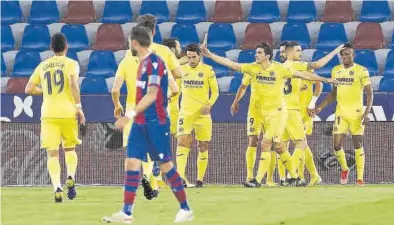  ?? EFE ?? Los jugadores del Villarreal felicitan a Gerard Moreno ante la mirada de algunos futbolista­s del equipo ‘granota’.