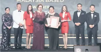  ??  ?? AirAsia East Malaysia Commercial head Nur Hayati Aziz Rashid (centre) receives the award from Sabah Deputy Chief Minister cum Minister of Tourism, Culture and Environmen­t Datuk Christina Liew, witnessed by Sabah Tourism general manager Noredah Othman and Sabah Tourism chairman Ken Pan (left) as well as Assistant Minister of Tourism, Culture, and Environmen­t Assafal P Alian and Permanent Secretary of the Ministry of Tourism, Culture and Environmen­t Datuk William Baya (right).