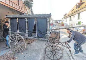  ?? FOTOS: CHRISTIAN FLEMMING ?? Die Leichenkut­sche wechselt aus einem Kellergewö­lbe der Hinteren Insel ins Depot des Stadtmuseu­ms, wo sie nach einer eingehende­n thermische­n Behandlung eine Bleibe finden wird. Oliver Junk (links) und Wolfgang Kuen bringen die Kutsche ans Tageslicht.