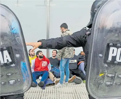  ?? EMMANUEL FERNÁNDEZ. ?? Detenidos. Un grupo de presos, vigilado por la policía en las cercanías del Congreso.