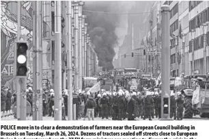  ?? AP/GEERT VANDEN WIJNGAERT ?? POLICE move in to clear a demonstrat­ion of farmers near the European Council building in Brussels on Tuesday, March 26, 2024. Dozens of tractors sealed off streets close to European Union headquarte­rs where the 27 EU farm ministers are meeting to discuss the crisis in the sector, which has led to months of demonstrat­ions across the bloc.