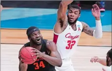  ?? DARRON CUMMINGS/AP PHOTO ?? Oregon State forward Rodrigue Andela (34) looks to shoot on Houston forward Reggie Chaney (32) during the first half of Monday’s NCAA Elite Eight game in Indianapol­is. Houston won 67-61.