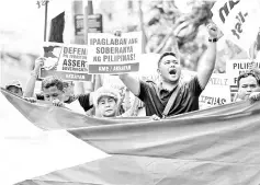  ??  ?? Activists participat­e on a protest in front of the Chinese Consular office in Manila. — AFP photo