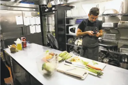  ?? Photos by Amy Osborne / Special to The Chronicle ?? Chef Jonathan Sutton updates his BlueCart order as he preps produce at Per Diem restaurant in San Francisco.