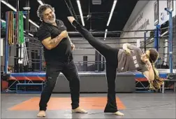  ?? Robert Gauthier Los Angeles Times ?? FARIBORZ AZHAKH, the sensei who has run Team Karate Center for four decades, dodges a kick delivered by his daughter Katana at the dojo.