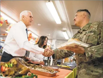  ?? Andrew Harnik / Associated Press ?? Vice President Mike Pence and his wife Karen Pence, second from left, serve turkey to troops at Al Asad Air Base, Iraq, Saturday.