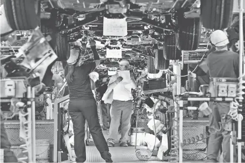  ??  ?? An employee fills out paperwork on the assembly line at the Subaru of Indiana Automotive Inc. in Lafayette, Indiana, on Wednesday, May 25. Manufactur­ing in June posted the strongest advance since January, helped by automobile production and a sign...