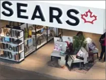  ?? NATHAN DENETTE, THE CANADIAN PRESS ?? Shoppers enter and leave a Sears store in Toronto last Thursday, the first day of a chain-wide liquidatio­n sale.