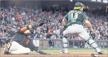  ?? MARCIO JOSE SANCHEZ — THE ASSOCIATED PRESS ?? The Giants’ Gorkys Hernandez, left, scores past A’s catcher Josh Phegley on a double by Steven Duggar on Saturday.