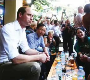  ?? POOL/KHAM/AFP ?? Britain’s Prince William (left) chats with Vietnamese residents at a cafe at the old quarters of Hanoi yesterday. Britain’s Prince William is in Vietnam to attend an internatio­nal conference on wildlife traffickin­g.