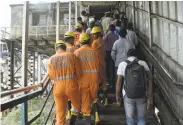  ?? Punit Paranjpe / AFP / Getty Images ?? Rescue personnel examine the scene of a stampede on a bridge connecting railway stations in Mumbai.