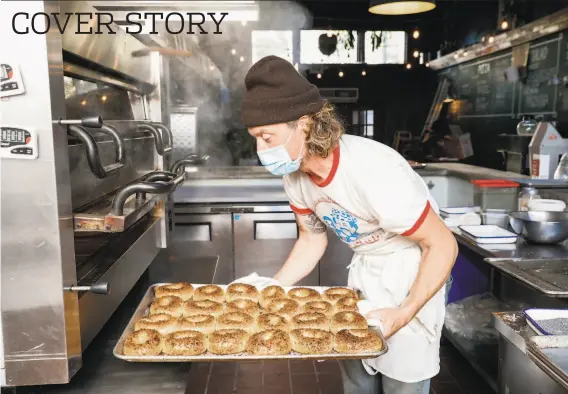  ?? Gabrielle Lurie / The Chronicle ?? Alex Rogers of the S.F. popup Chicken Dog Bagels, above, puts bagels in the oven. The bagels at Schlok’s S.F. popup, below, are hefty with a maltier flavor.