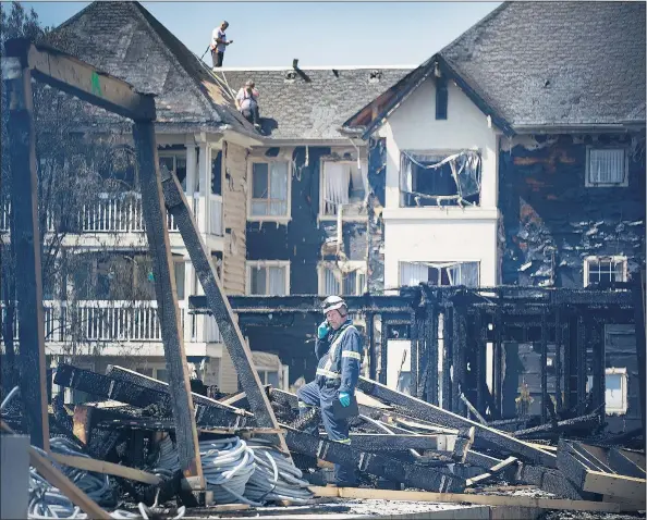  ?? PHOTOS: ARLEN REDEKOP/PNG ?? Residents were left homeless Monday after a fire at a constructi­on site Sunday near their townhouse complex on 221st Street at 49th Avenue in Langley. The apartment building under constructi­on was destroyed and the fire spread to the occupied complex...