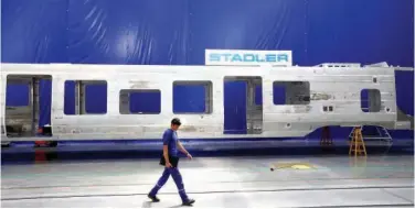  ?? Reuters ?? ↑ An employee walks past an electric train assembly line at the Stadler Minsk plant in Fanipol, Belarus.